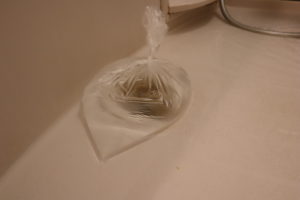 透明のビニール袋に水を入れてお風呂場の排水溝に置いている写真