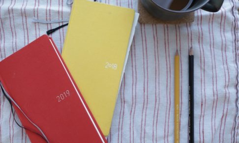 2018年と2019年のほぼ日手帳とコーヒーカップと鉛筆を並べている写真