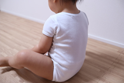 ボンポワンの半袖ボディ肌着12Mサイズを1歳6か月の娘に着せて座っているとこの後ろ姿を撮った写真