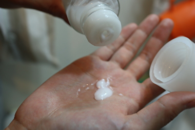 アイハーブで買ったビタミンEオイルと松山油脂の乳液を手の平に出している写真