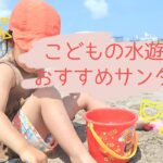 娘が海の砂浜に座ってお砂場道具で遊んでいるところ